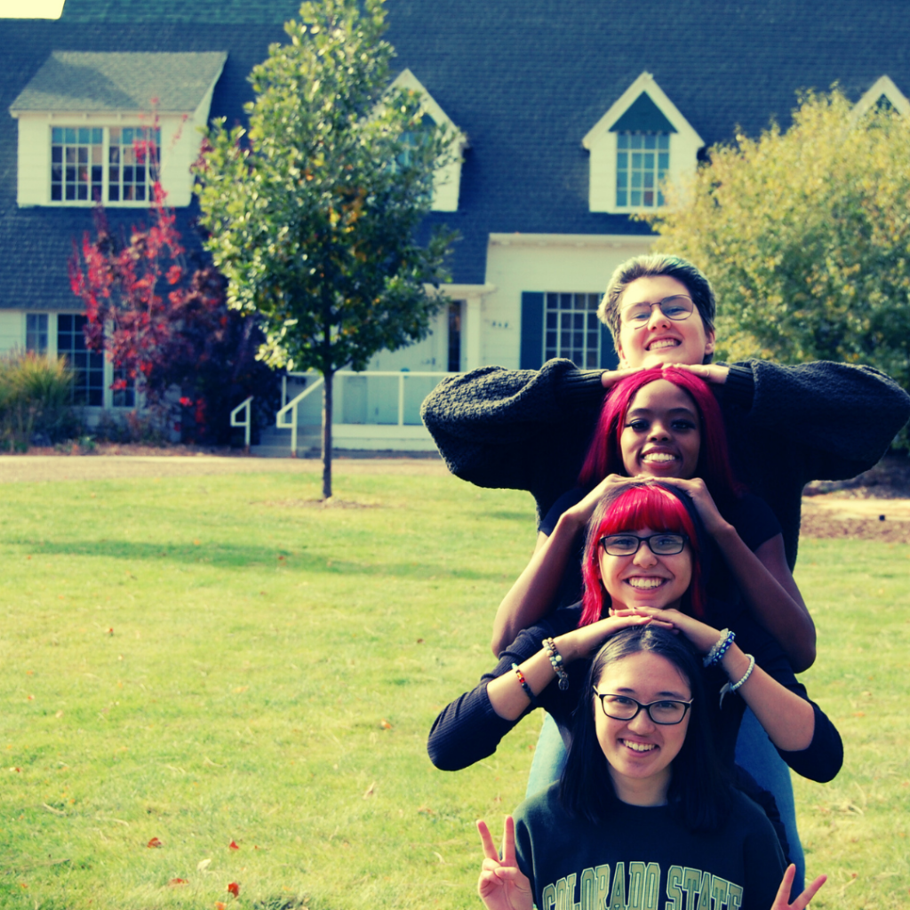 Student educators playfully pose in front of the Mary Ontiveros House at CSU